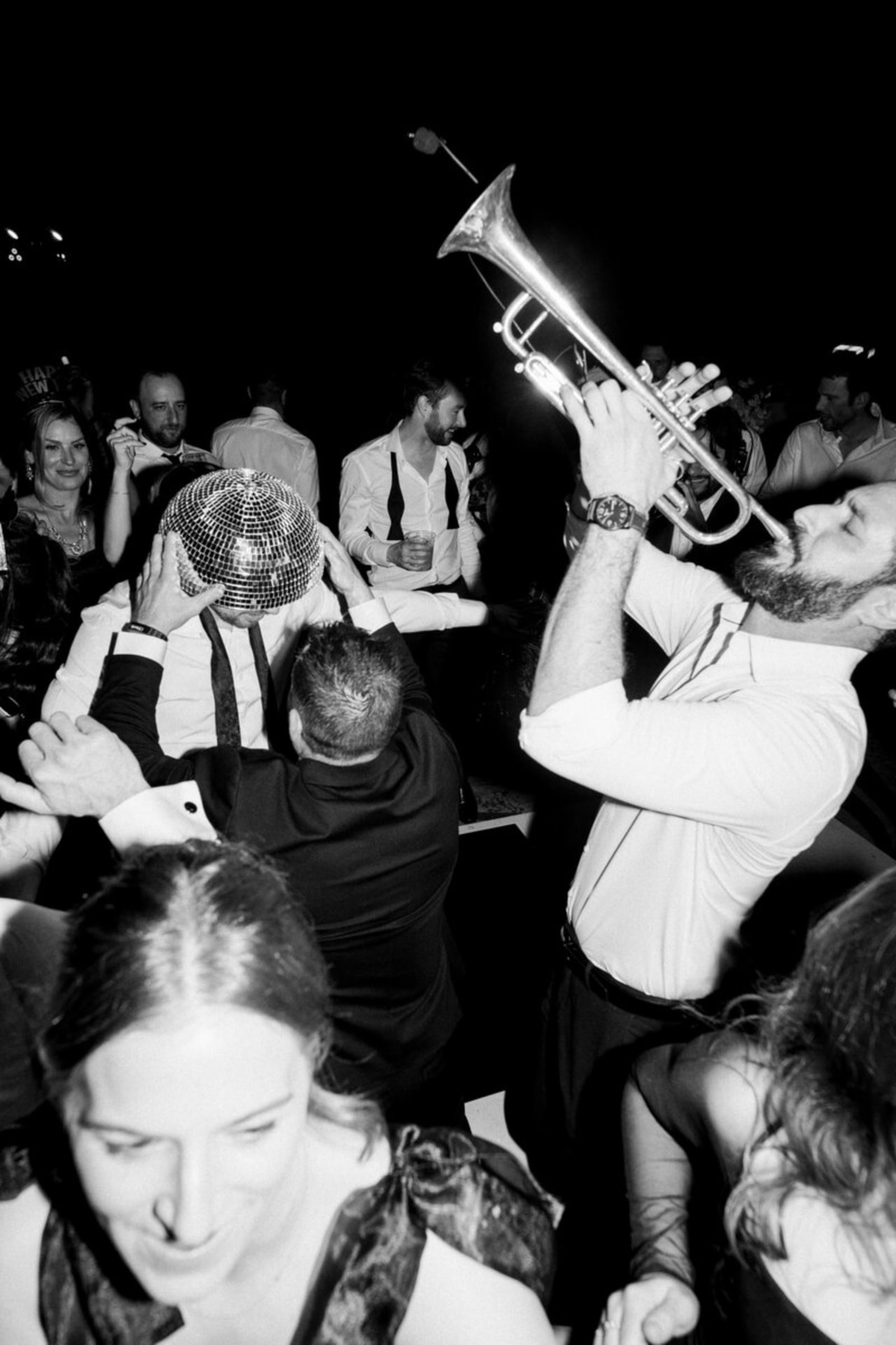 Guests celebrating on a dance floor as a trumpeter plays